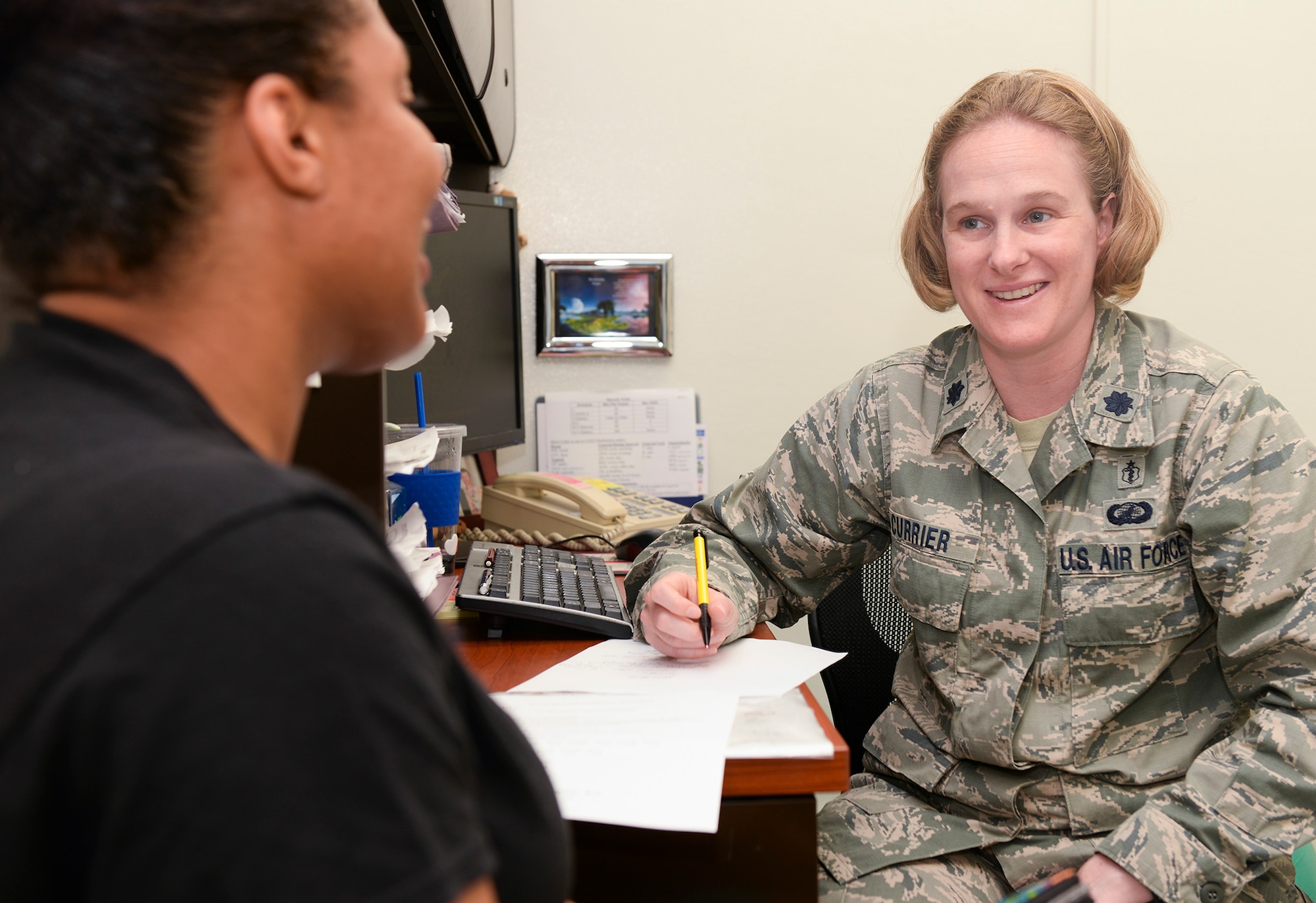 Lt. Col. Linda Currier, 374th Surgical Operations Squadron surgical services flight commander, discusses the recovery process with Tech. Sgt. Terriona Sutton at Yokota Air Base, Japan, June 6, 2015. Among other examinations, Sutton demonstrated a number of strength training and stretching movements to show Currier her progress since her knee injury eight months prior. (U.S. Air Force photo by Airman 1st Class Elizabeth Baker/Released)