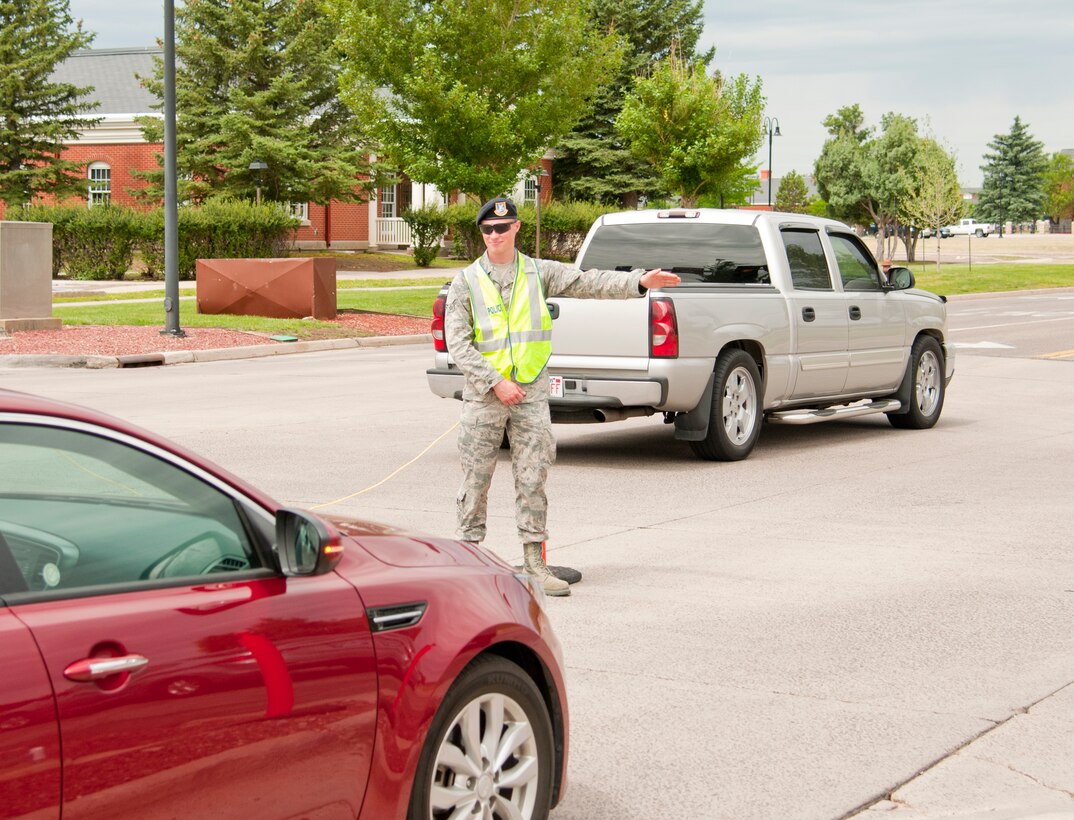 Airman 1st Class Scott Cox, 90th Security Forces Squadron, directs traffic , July 19, 2015, toward Fort D.A. Russell Days on F.E. Warren Air Force Base, Wyo. Cox and fellow Airmen maintained security during the open house, which attracted record numbers of visitors this year. (U.S. Air Force photo by Senior Airman Jason Wiese)