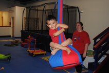 Xavier Ortega, 3, enjoys the zip line as Kids Gym owner and operator
Allison Mersel assists children during open play July 17. (Air Force photo by Jim Fisher)
