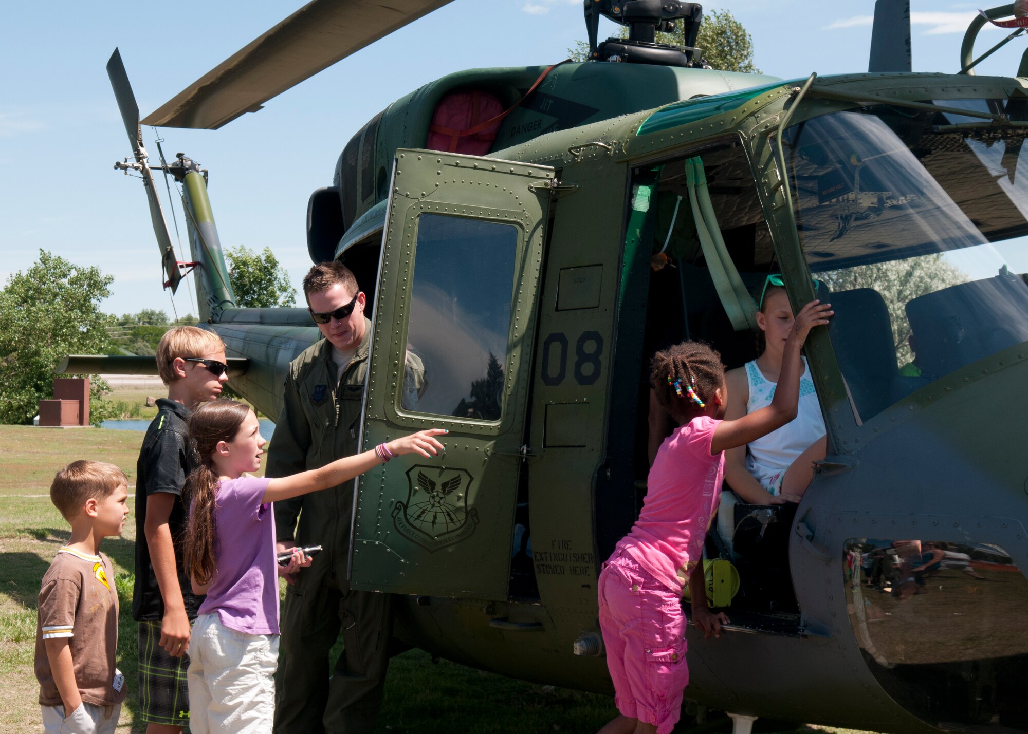 Staff Sgt. Timothy Nissen, 37th Helicopter Squadron, talks about a UH-N1 Huey helicopter, July 18, 2015, that was on display during the F.E. Warren Air Force Base, Wyo., open house, Fort D.A. Russell Days. The purpose of the open house is to help educate the public on the past and current missions of the 90th Missile Wing. (U.S. Air Force photo by Airman 1st Class Brandon Valle)