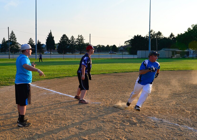 Creston Sherwood, 436th Maintenance Squadron base coach/catcher, directs a 436th MXS runner to turn third base and run home during an intramural softball game against the 436th Security Forces Squadron July 20, 2015, at the softball field on Dover Air Force Base, Del. The 436th MXS were the last undefeated team in the American League but lost to the 436th SFS, 11-10. (U.S. Air Force photo/Airman 1st Class William Johnson)