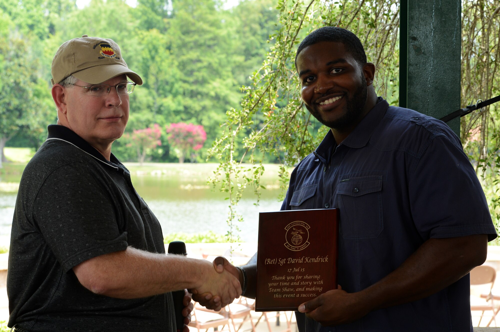 Retired Army Sgt. David Kendrick, an Iraq War veteran and former AbilityOne employee, receives a plaque from Randy May, 20th Contracting Squadron director, during the AbilityOne Employee Appreciation Picnic at Memorial Lake, July 17, 2015, at Shaw Air Force Base, S.C.. Kendrick, who was shot in the leg by a sniper and medically retired, worked for AbilityOne to get back on his feet and now owns his own business in Atlanta, Ga. (U.S. Air Force photo by Senior Airman Jonathan Bass/Released)