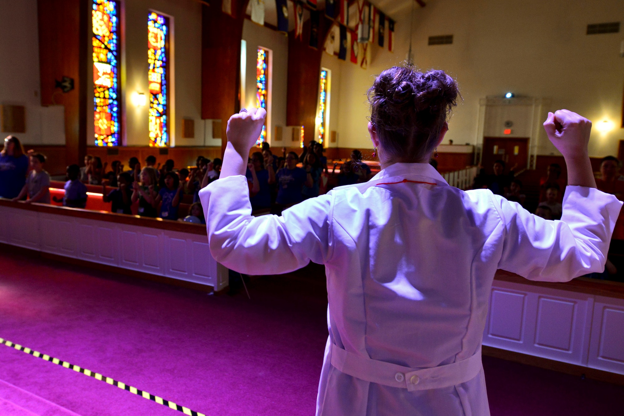 Amy Quinlan, Regimental Chapel Vacation Bible School volunteer, leads school attendees in a song and dance at the chapel on Fort Eustis, Va., July 14, 2015. Each morning of the week-long school began with a song and dance pertaining to the week’s various lessons.  (U.S. Air Force photo Staff Sgt. Natasha Stannard/Released)