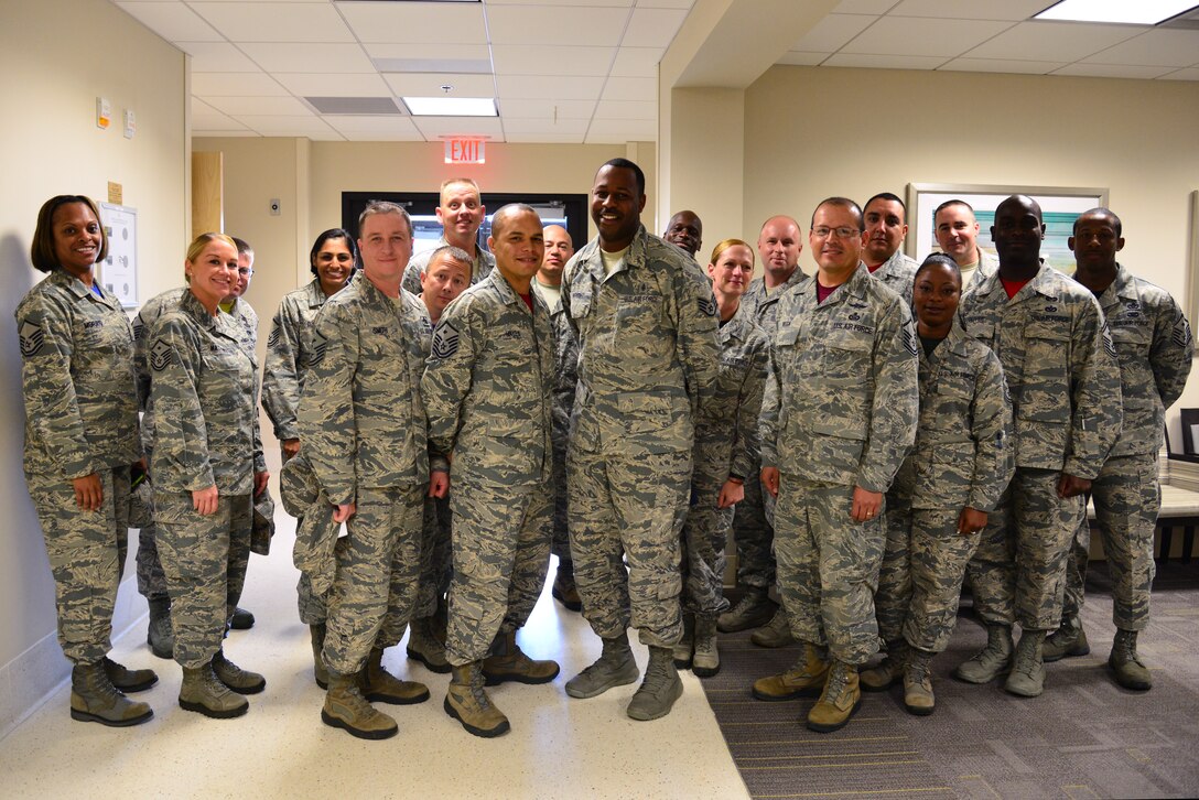 U.S. Air Force first sergeants congratulate Staff Sgt. Thomas Wright, 633rd Surgical Operations Squadron diagnostic imaging sonographer, (center), for receiving a Diamond Sharp award at Langley Air Force Base, Va., July 17, 2015. Wright took 10 days of personal leave to accompany an Airman who needed assistance with arrangements when his mother passed away. (U.S. Air Force photo by Senior Airman Aubrey White/Released)