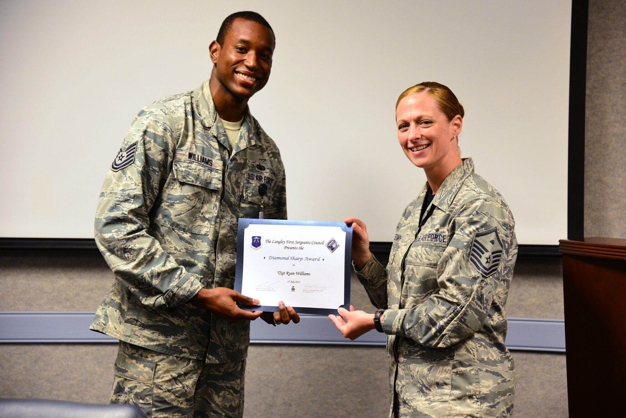 U.S. Air Force Tech. Sgt. Michael Williams, 83rd Network Operations Squadron unit deployment manager, accepts a Diamond Sharp award from Master Sgt. Rachel Singletary, 83rd NOS first sergeant, at Langley Air Force Base, Va., July 17, 2015. The quarterly award recognizes Airmen whose performance stood out among their peers. (U.S. Air Force photo by Senior Airman Aubrey White/Released)