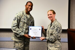 U.S. Air Force Tech. Sgt. Michael Williams, 83rd Network Operations Squadron unit deployment manager, accepts a Diamond Sharp award from Master Sgt. Rachel Singletary, 83rd NOS first sergeant, at Langley Air Force Base, Va., July 17, 2015. The quarterly award recognizes Airmen whose performance stood out among their peers. (U.S. Air Force photo by Senior Airman Aubrey White/Released)