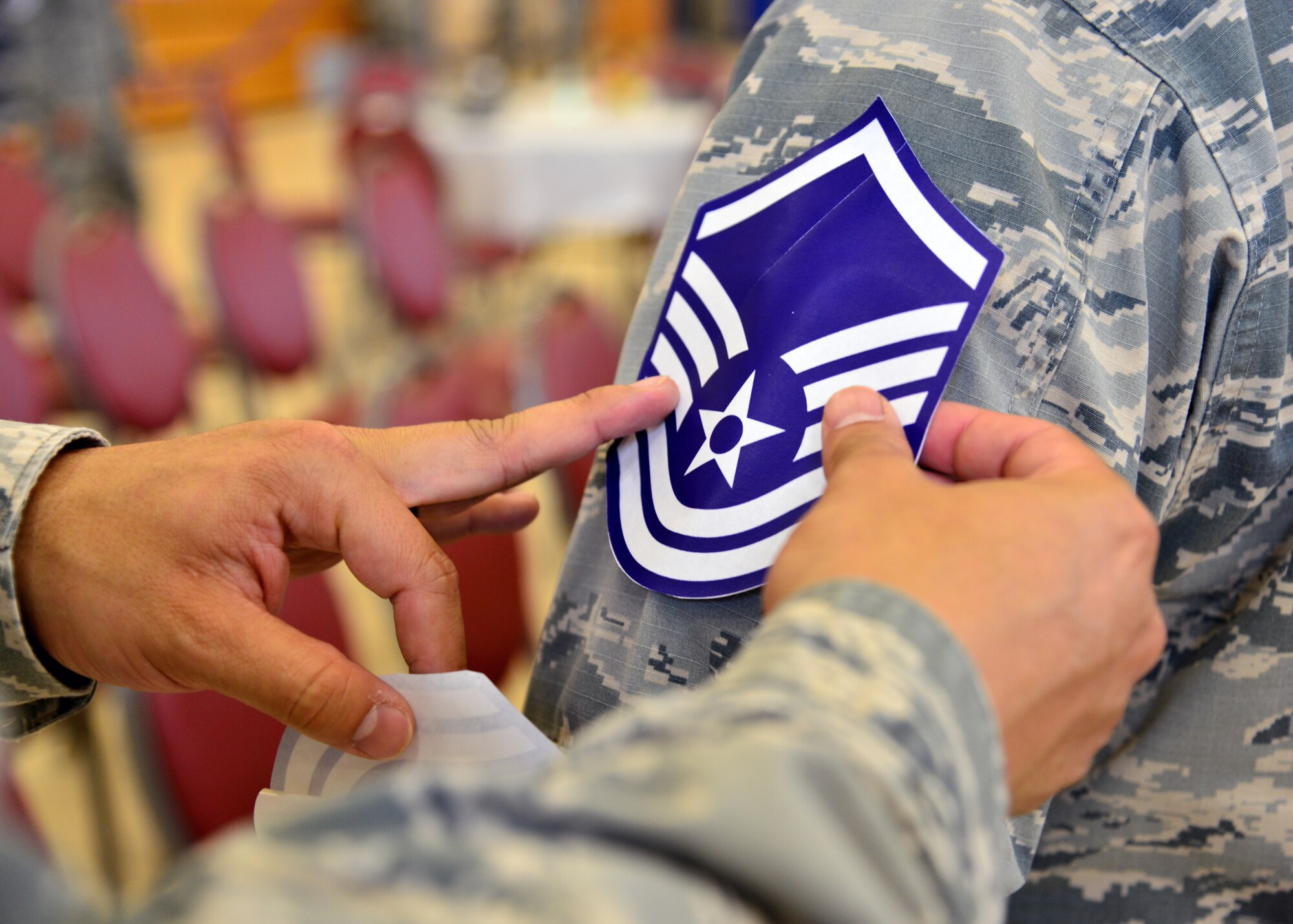 A U.S. Air Force Airman places a master sergeant stripes sticker onto the arm of a technical sergeant selected for promotion before a promotion party at Langley Air Force Base, Va., July 16, 2015. The Air Force selected 5,301 technical sergeants out of 23,619 eligible Airmen for promotion to master sergeant, according to Air Force Personnel Center officials. (U.S. Air Force photo by Senior Airman Aubrey White/Released)