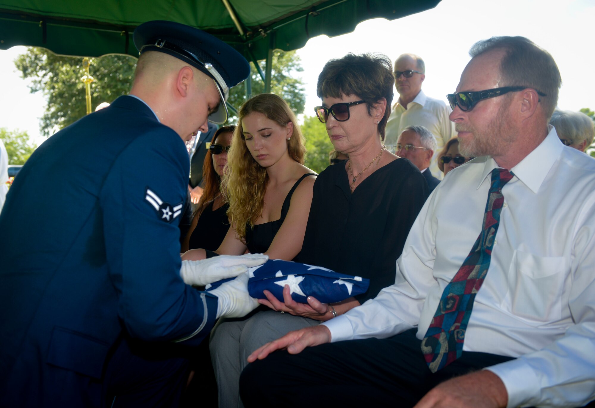 Airman 1st Class Joseph Meskimen, Barksdale Honor Guard, presents an American flag to the next of kin during a funeral in Bossier City, La., July 27, 2015. Meskimen presented the flag and delivered a message of condolence stating “On behalf of the President of the United States, the United States Air Force and a grateful nation, please accept this flag as a token of your loved one’s faithful and honorable service,” to the next of kin. (U.S. Air Force photo/Airman 1st Class Mozer O. Da Cunha)

