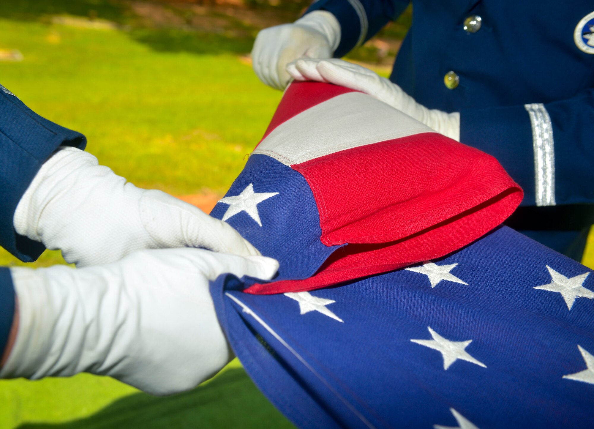 Senior Airman Ryan Fratacia and Airman 1st Class Joseph Meskimen, Barksdale Honor Guardsmen, perform the folding of the flag during a funeral in Bossier City, La., July 27, 2015. Honor Guard Airmen perform at a variety of ceremonies such as retirement ceremonies, promotion ceremonies, and serve as pall-bearers to honor veterans and retirees (U.S. Air Force photo/Airman 1st Class Mozer O. Da Cunha)

