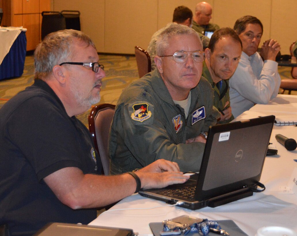 04.	Paul Bartko, Federal Aviation Administration Systems Operations Security, goes over some air plan information with  Lt. Gen. William Etter, Commander, Continental U.S. Northern Aerospace Defense Region – 1st Air Force (Air Forces Northern), during an outbrief at the 2015 Multi-State Hurricane Air Coordination Plan Workshop  July 14-15 at Tyndall Air Force Base, Fla. The workshop brought together representatives from across the federal and state crisis-response enterprise to develop a plan for a common air picture among multiple states during a hurricane response. (Air Force Photo Released/Mary McHale)