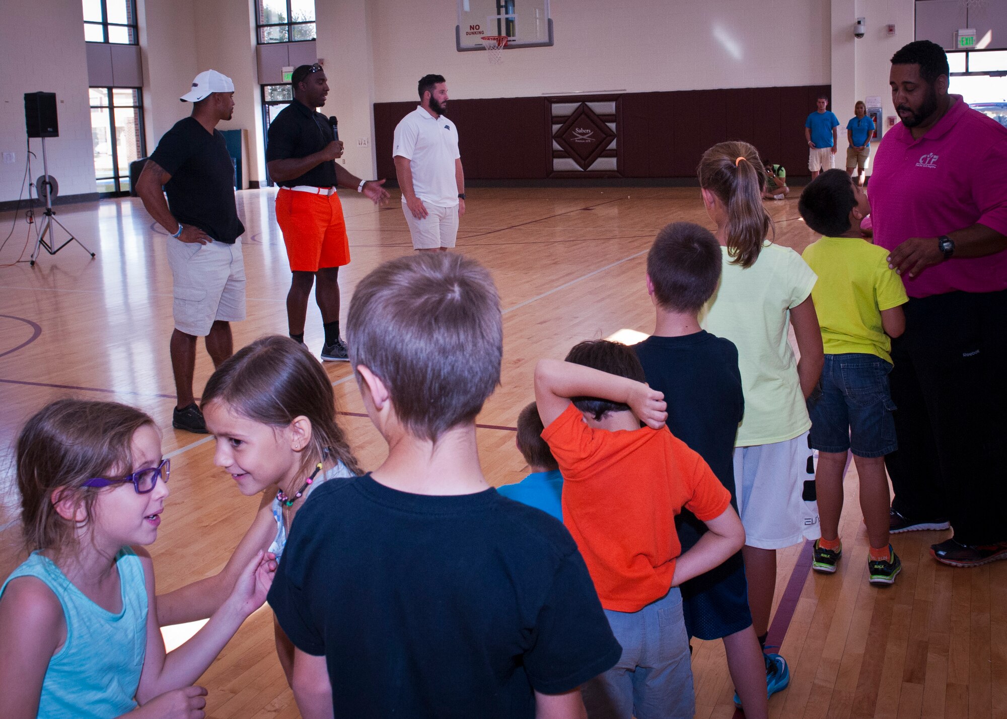 PETERSON AIR FORCE BASE, Colo. – Youth wait in line to ask professional football players questions about football and life at the R.P. Lee Youth Center, July 13, 2015. The pros in attendance were (from left) Anthony Trucks, former Pittsburgh Steelers linebacker; Greg Scruggs, Seattle Seahawks defensive end and Brian Folkert, center for the Carolina Panthers. They were at Peterson for the Pro Football Camp, which reaches out to communities and encourage youth. (U.S. Air Force photo by Airman 1st Class Rose Gudex)