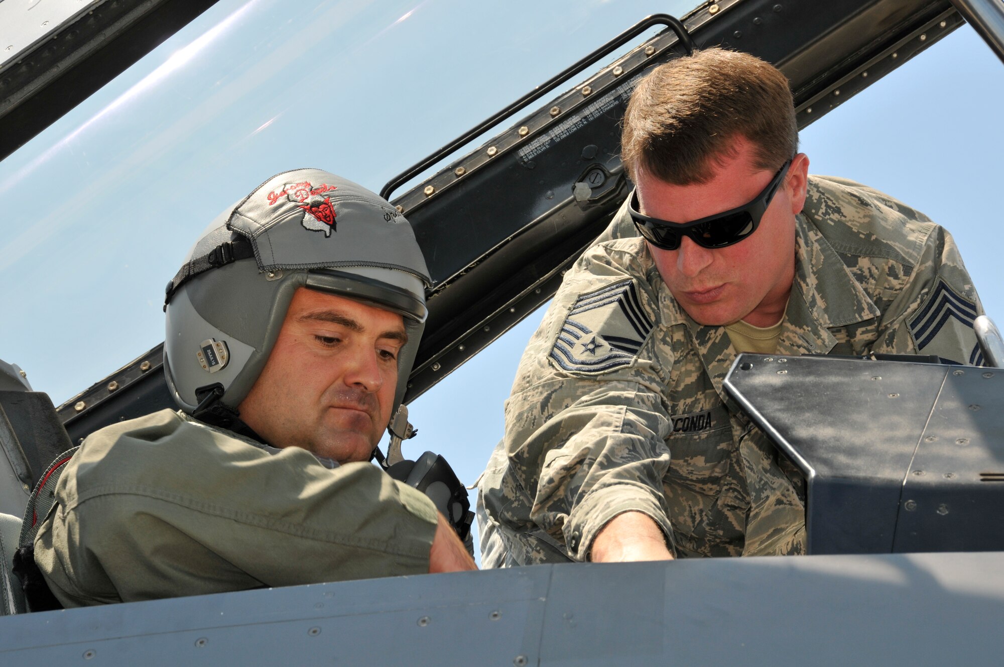A picture of U.S. Air Force Chief Master Sgt. Jason Gioconda, aircrew flight equipment superintendent, going over egress procedures with Bulgarian air force MiG-29 pilot Capt. Ivan Dinkov.