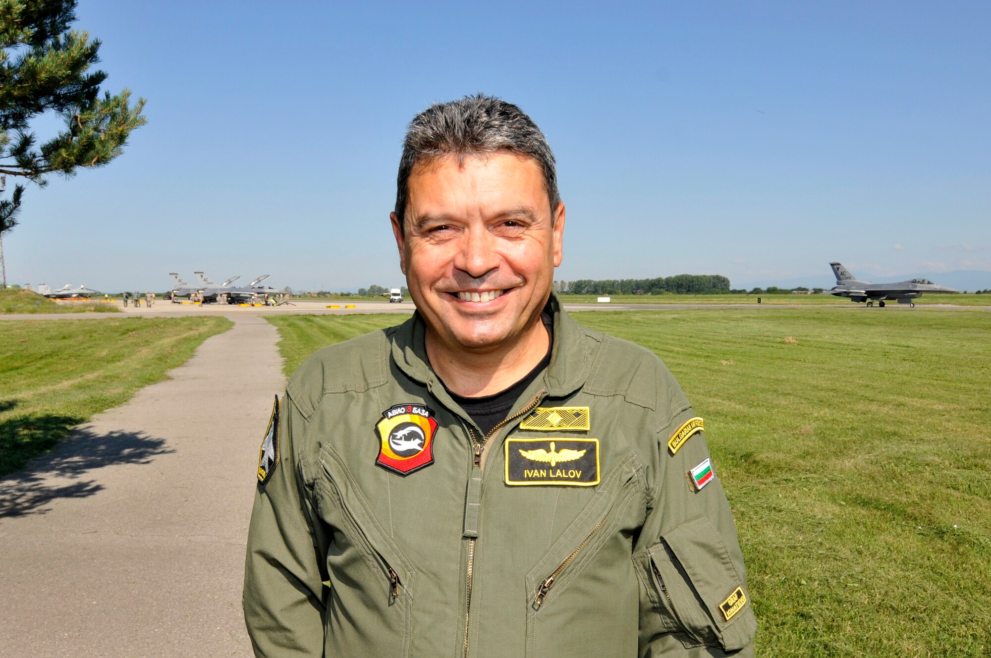 A picture of Bulgarian air force Brig. Gen. Ivan Lalov, Graf Ignatievo Air Base commander, posing for a photo with U.S. Air Force F-16 Fighting Falcons in the background.