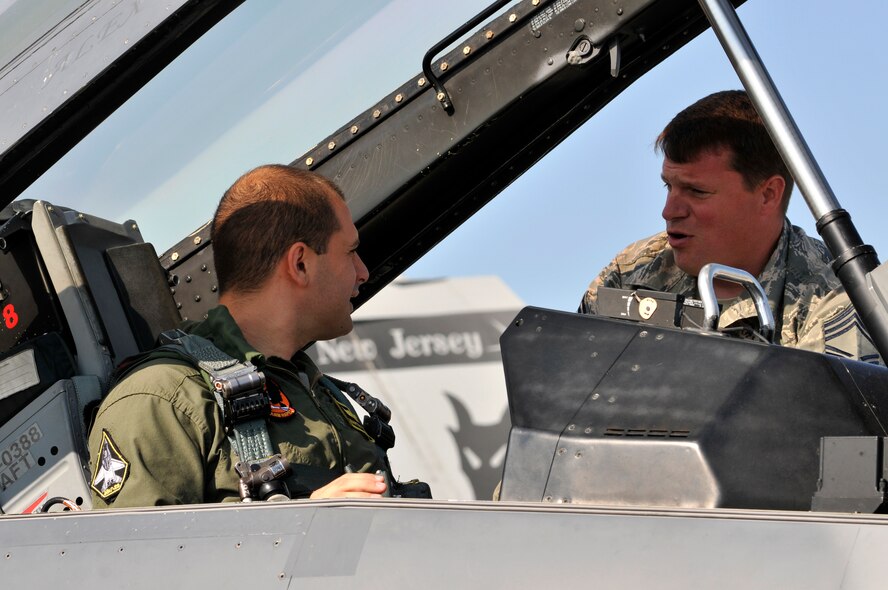 U.S. Air Force Chief Master Sgt. Jason Gioconda, aircrew flight equipment superintendent with the 177th Fighter Wing of the New Jersey Air National Guard, goes over egress procedures with Bulgarian air force MiG-29 pilot Capt. Martin Vetov prior to his familiarization flight in an F-16D Fighting Falcon at Graf Ignatievo Air Base, Bulgaria, on July 13, 2015. Gioconda and Vetov are participating in Thracian Star, a bilateral training exercise to enhance interoperability with the Bulgarian air force and to bolster readiness to conduct combined air operations. (U.S. Air National Guard photo by Master Sgt. Andrew J. Moseley/Released)