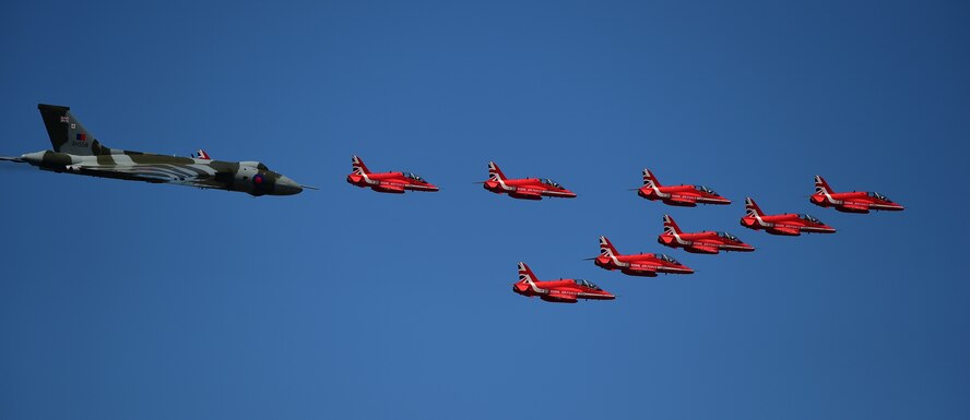 An Auro Vulcan B2 XH558, flies in formation with the Royal Air Force Red Arrows during the Royal International Air Tattoo in RAF Fairford, United Kingdom, July 19, 2015. The Red Arrows were established in 1965, are in their 51st display season. (U.S. Air Force photo by Tech. Sgt. Chrissy Best/Released)