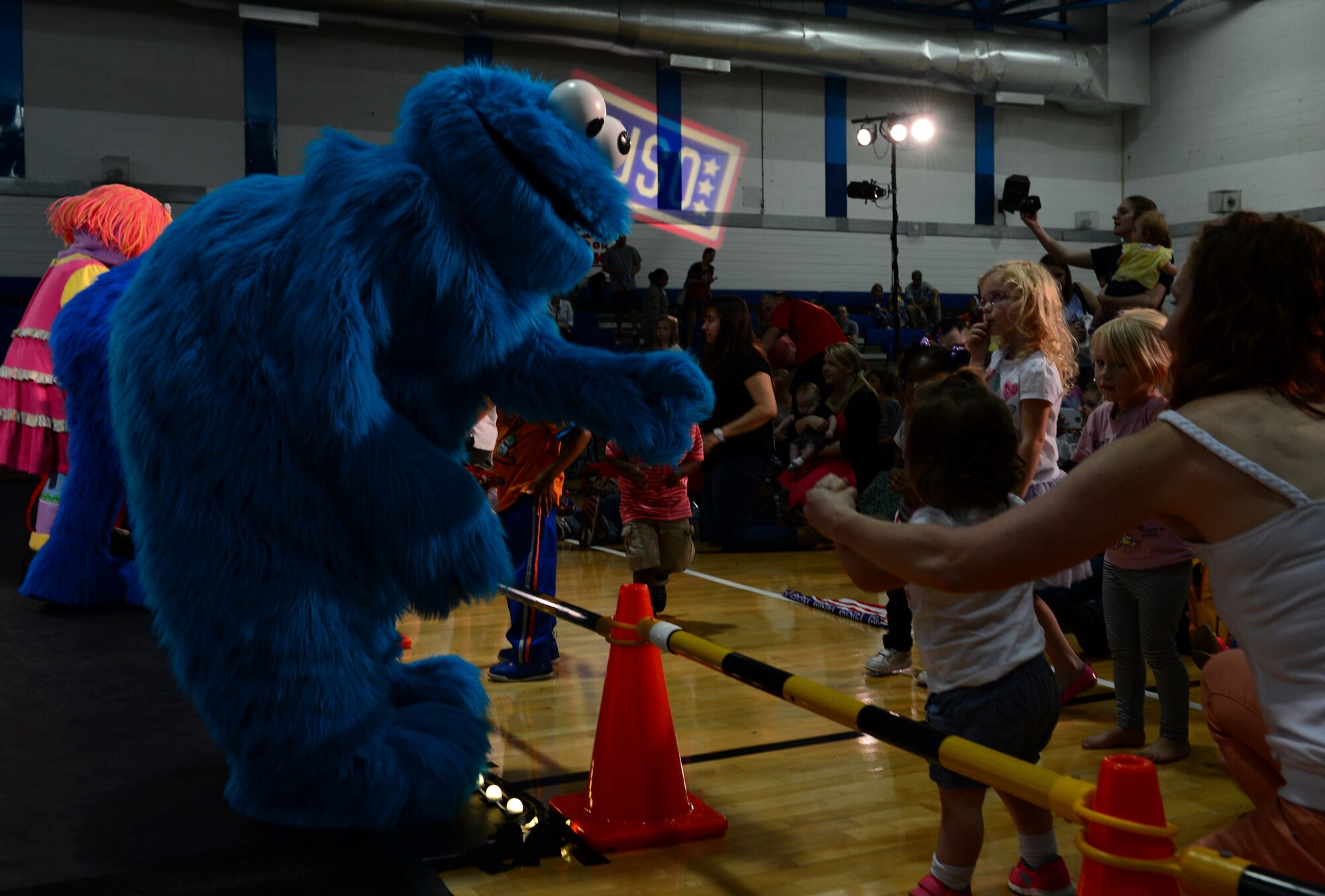 Sesame Street’s Cookie Monster greets Airmen and their children during a Sesame Street/USO Experience at Royal Air Force Lakenheath, England, July 20, 2015. The Sesame Street/USO Experience for Military Families is the USO’s longest-running, free-traveling tour based on Sesame Street's Military Family Initiative. (U.S. Air Force photo by Senior Airman Dawn M. Weber/Released)