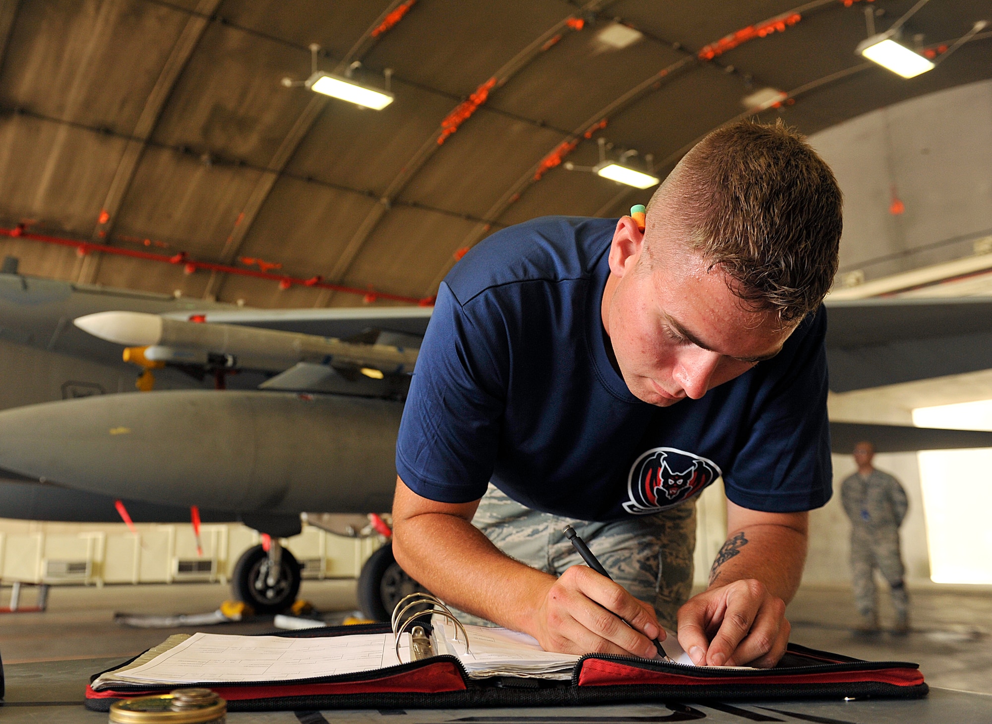 U.S. Air Force Airman 1st Class Jacob Clark, 18th Aircraft Maintenance Squadron weapons load crew member, annotates his checklist during the second-quarter weapons load competition on Kadena Air Base, Japan, July 17, 2015. Weapons load competitions are conducted quarterly to keep Airmen sharp and recognize superior performers. Teams are evaluated for use of the checklist, safety and overall speed. (U.S. Air Force photo by Naoto Anazawa)