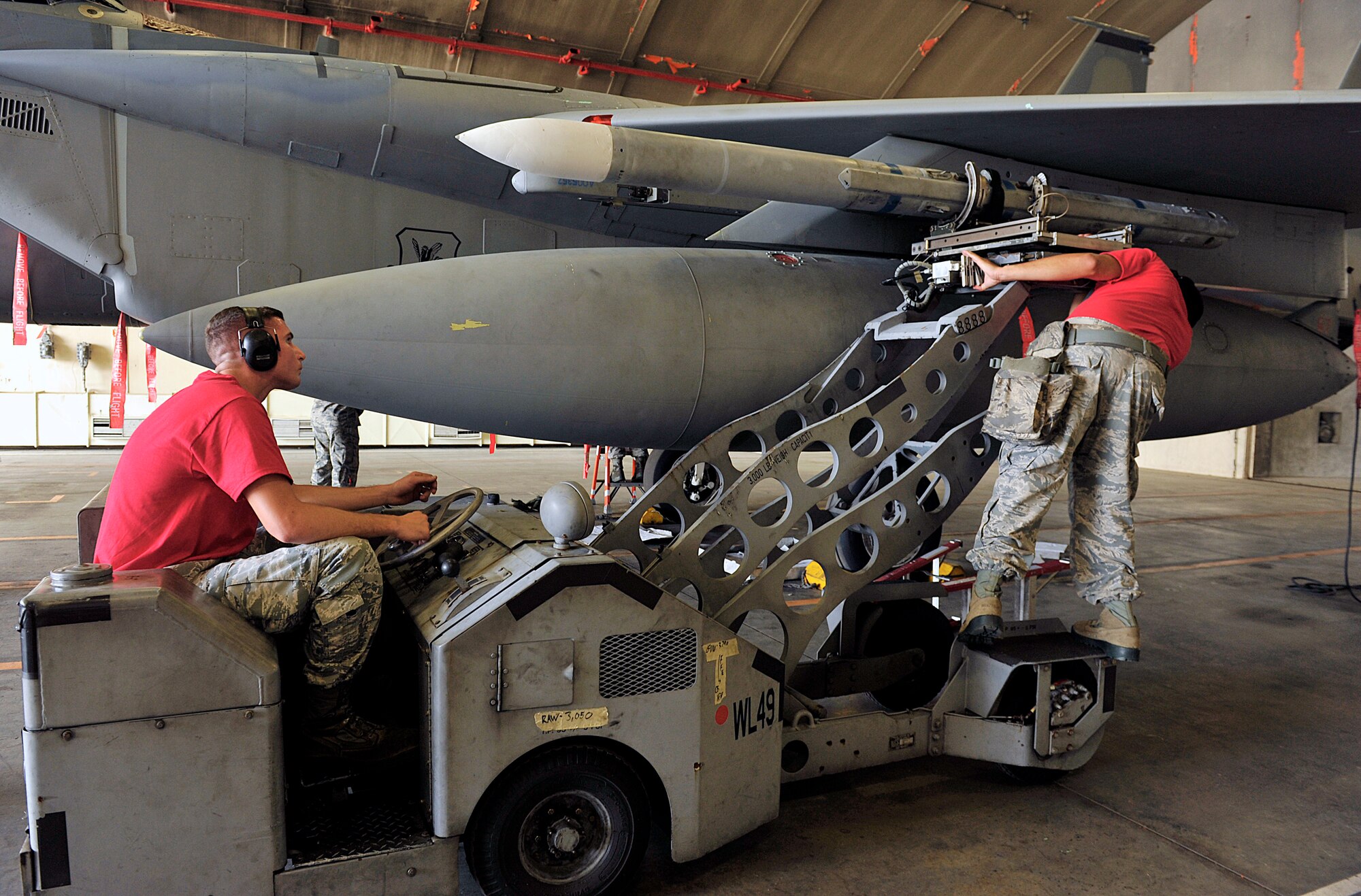 A U.S. Air Force weapons load crew from the 67th Aircraft Maintenance Unit attaches an AIM-120 advanced medium-range air-to-air missile onto a U.S. Air Force F-15C Eagle during the second-quarter weapons load competition on Kadena Air Base, Japan, July 17, 2015. During the competitions, each team must load an AIM-9L/M Sidewinder missile and an AIM-120 missile onto an F-15C Eagle with speed and precision. (U.S. Air Force photo by Naoto Anazawa)