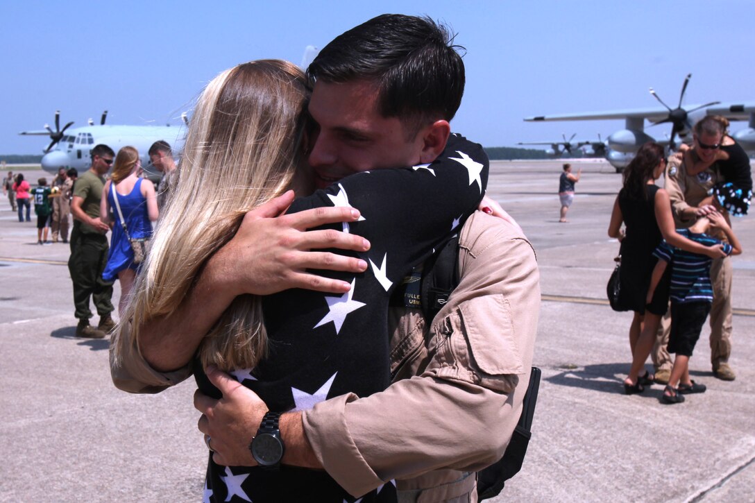 Cpl. Christopher Fuller, a crew chief with Marine Aerial Refueler Transport Squadron 252, embraces his wife, Jessica Fuller during a return celebration for the Marines of VMGR-252 at Marine Corps Air Station Cherry Point, North Carolina, July 20, 2015. Eighty Marines arrived in VMGR-252’s hangar to meet their families for the first time in half a year, after returning from a deployment in Moron Air Base, Spain, maintaining readiness for crisis response in Africa.