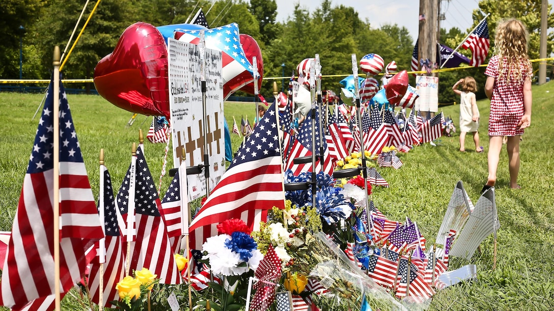 Chatanooga residents place hundreds of American flags and create makeshift memorials along the road outside the Navy Operational Support Center and Marine Corps Reserve Center in Chattanooga, Tennessee on July 20, 2015 to honor and remember the four brave Marines and one brave Sailor that were shot and killed by a gunman in Chattanooga on July 16, 2015.