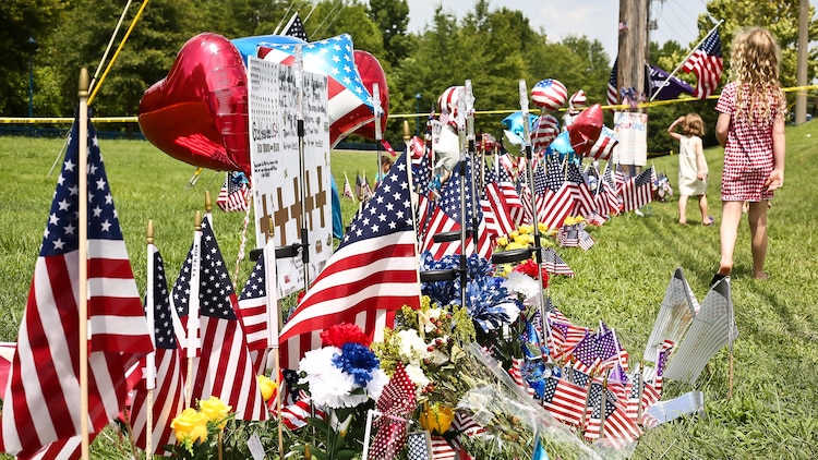 Chatanooga residents place hundreds of American flags and create makeshift memorials along the road outside the Navy Operational Support Center and Marine Corps Reserve Center in Chattanooga, Tennessee on July 20, 2015 to honor and remember the four brave Marines and one brave Sailor that were shot and killed by a gunman in Chattanooga on July 16, 2015.