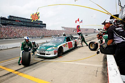 Dale Earnhardt Jr., driver of the No. 88 National Guard NASCAR racecar, sits in his pit box as the No. 88 pit crew rushes to get the National Guard NASCAR racecar back into the race at Michigan International Speedway in Brooklyn, Mich., Sunday June 19, 2011.