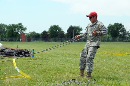 Army Spc. Justin Robinson of the Nebraska Army National Guard's Detachment 2,
165th Quartermaster Company, attaches cables to massive sandbags containing
2,000 to 2,500 pounds of sand on June 17, 2011 at Eppley Airfield in Omaha,
Neb. Robinson and several other 165th Soldiers were preparing the bags to be
dropped at a nearby levee in the event of an emergency.