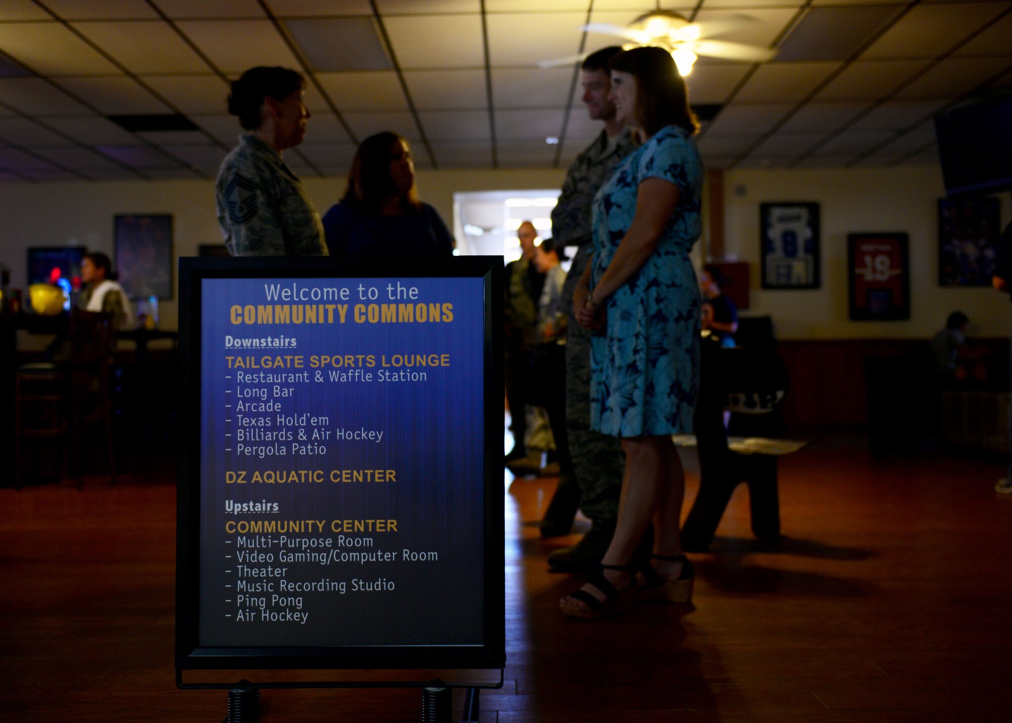 Air Commandos congregate in front of a sign featuring a list of activities available to patrons at the Drop Zone June 4, 2015 at Cannon Air Force Base, N.M. To facilitate better quality of life for Airmen and families at the 27th Special Operations Wing, the Drop Zone received an extensive renovation to incorporate a dine-in restaurant, video gaming lounge, bar, and a host of additional attractions. (U.S. Air Force photo/Airman 1st Class Shelby Kay-Fantozzi)