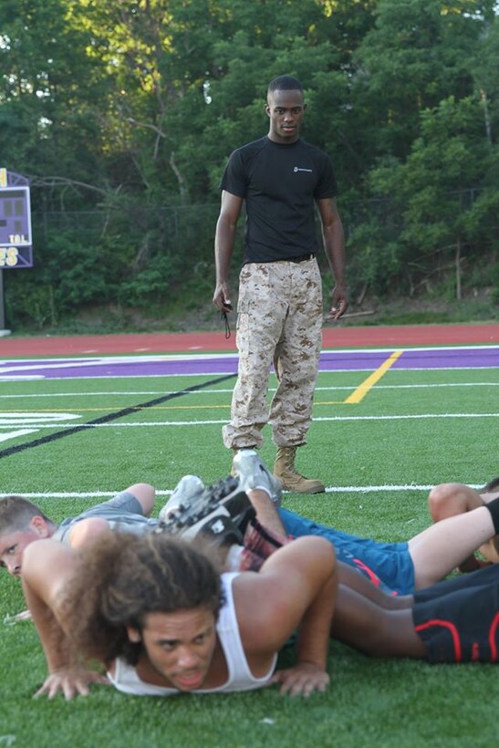 Marines with Recruiting Station Albany, NY, motivate athletes of the Troy High School football team through a circuit course at the school’s football field in Troy, NY, Tuesday, July 21, 2015. The circuit course was the concluding exercise in a leadership seminar the Marines conducted for the football team. 