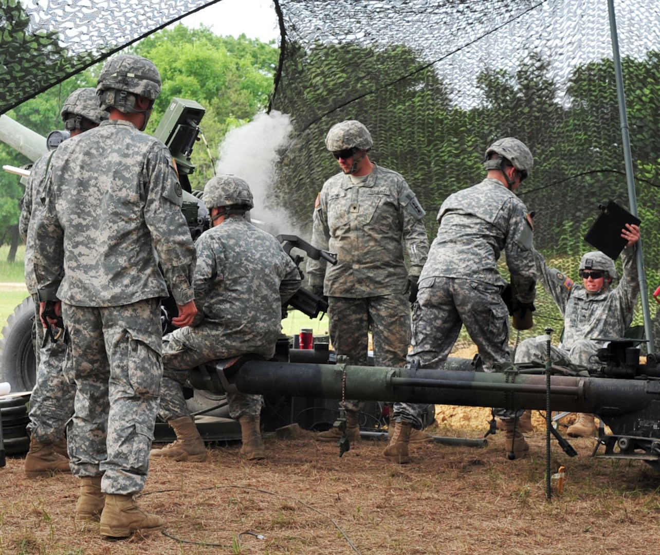 The howitzer crew from Gun 3, Battery A, 1st Battalion, 120th Field Artillery celebrates as they inspect their cannon following a successful first shot. Deployments have silenced the 120th's cannons for six years. 32nd Infantry Brigade Combat team.