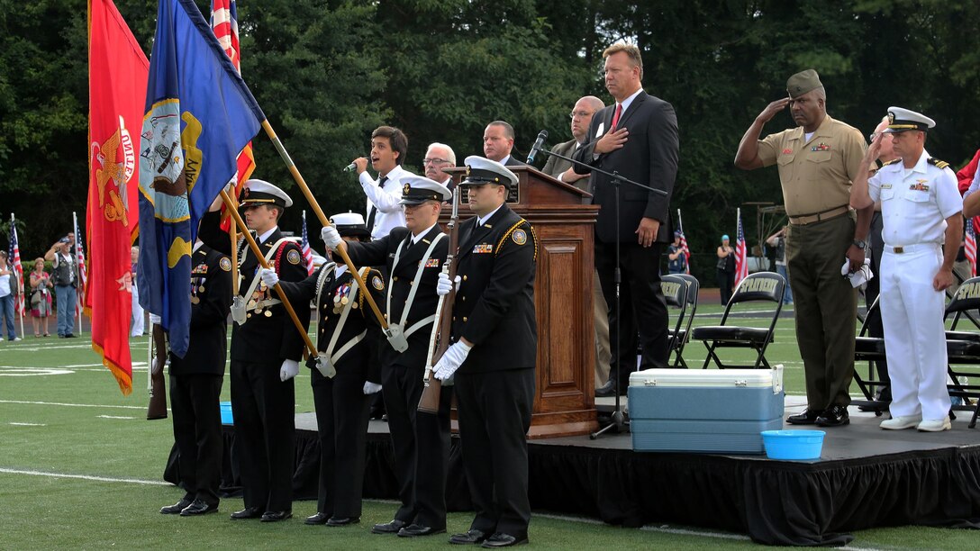 The Sprayberry JROTC presents the colors as the National Anthem is sung at Lance Cpl. Squire Wells memorial in Marietta, Georgia on July 21, 2015. Wells was killed in an attack by a gunman at the Naval Operational Support Center and Marine Corps Reserve Center in Chattanooga, Tennessee on July 16, 2015. Marines, family, friends and the community gathered together at the high school stadium to pay their respects and thank Wells for his sacrifice and selfless service. 