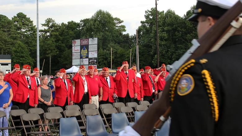 Veterans with the Marine Corps League of Woodstock, Georgia stand and salute the colors as they pass by during Lance Cpl. Squire Wells memorial at Sprayberry High School in Marietta, Georgia, July 21, 2015. Wells is one of five service members to be killed when a gunman entered the Naval Operational Support Center and Marine Corps Reserve Center in Chattanooga, Tennessee on July 16, 2015. Marines, veterans, family, friends and community members gathered in the high school’s stadium to honor Wells and the sacrifices he made for his country.