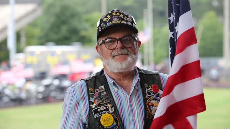 Roderick Allen, a navy veteran, holds an American flag at Lance Cpl. Squire Wells memorial at Sprayberry High School in Marietta, Georgia, July 21,2015. Veterans and volunteers like Allen surrounded the field of the high school stadium all carrying American flags to honor and pay their respects to Wells and his family. The memorial brought in hundreds of people also looking to thank Wells for his service to this country.