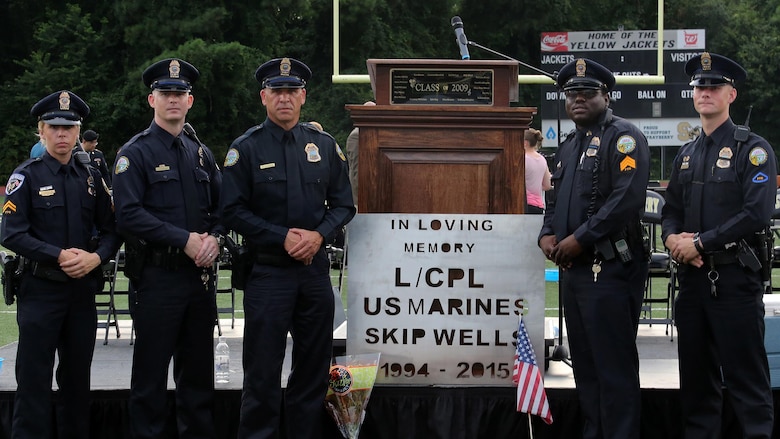 Police Officers with the Chattanooga Police Department pose for a picture by a plaque dedicated to Lance Cpl. Squire Wells during his memorial service in Marietta, Georgia, July 21, 2015. Wells was one of the Marines killed during an attack by a gunman at the Naval Operational Support Center and Marine Corps Reserve Center where police officers fought to subdue the gunman. Wells, his fellow Marines and the police officers all displayed heroism during the attack and are honored and recognized for their selfless service. 