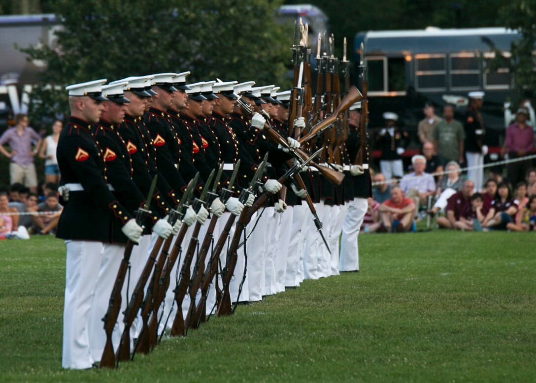 The Silent Drill Platoon, Marine Barracks Washington, D.C., performs during a Tuesday Sunset Parade at the Marine Corps War Memorial in Arlington, Va., July 21, 2015. The guest of honor for the Sunset Parade was Staff Sgt. Liam Dwyer and the hosting official for that same parade was Lt Gen. Mark A. Brilakis, deputy commandant of Manpower and Reserve Affairs. (U.S. Marine Corps photo by Cpl. Christian Varney/Released)