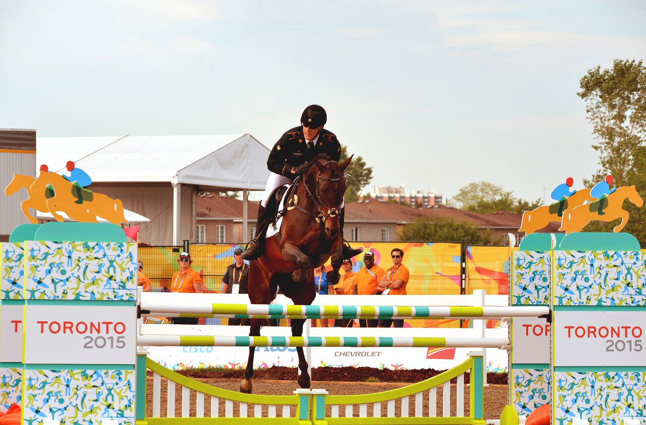 Army Spc. Nathan Schrimsher of the U.S. Army World Class Athlete Program rides a horse named Taboo, en route to earning a berth for the 2016 Olympic Games with a third-place finish in men's Modern Pentathlon at the 2015 Pan American Games in Toronto, July 19, 2015. U.S. Army photo by Tim Hipps