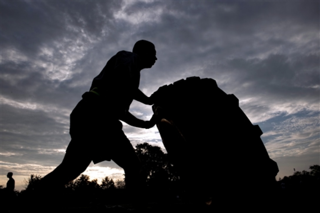 Army Sgt. Earnest Knight flips a tire during the 3rd annual U.S. Army Spc. Hilda I. Clayton Best Combat Camera 2015 on Fort Meade, Md., July 13, 2015. Knight is a combat documentation production specialist assigned to the 55th Signal Company. The competition honors the fallen combat cameraman, Army Spc. Hilda I. Clayton, who gave her life July 2, 2013, in Afghanistan as a part of Operation Enduring Freedom.