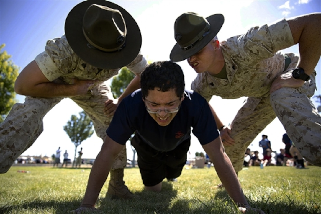 Marine Corps Sgts. Stephen Wills, left, and Brandon Hendrix motivate Jose Garcia, a Marine enlistee, during a pool function at the Yakima Training Center in Yakima, July 17, 2015. During the event, recruiters teamed with drill instructors to physically and mentally prepare enlistees from Washington and Idaho for boot camp. Wills and Hendrix are drill instructors assigned to the Marine Corps Recruit Depot San Diego.  