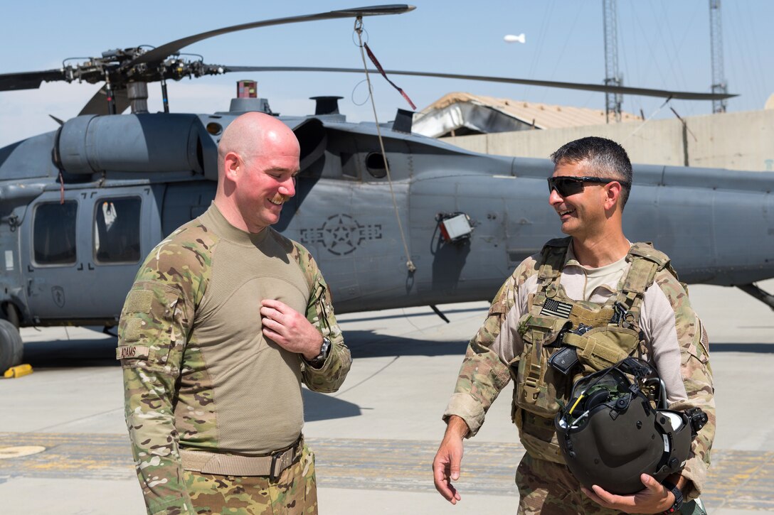 U.S. Air Force Brig. Gen. Dave Julazadeh, right, commander of 455th Air Expeditionary Wing, talks with an HH-60 Pave Hawk helicopter pilot during an immersion tour on Bagram Airfield, Afghanistan, July 16, 2015. The pilot is assigned to the 83rd Expeditionary Rescue Squadron.