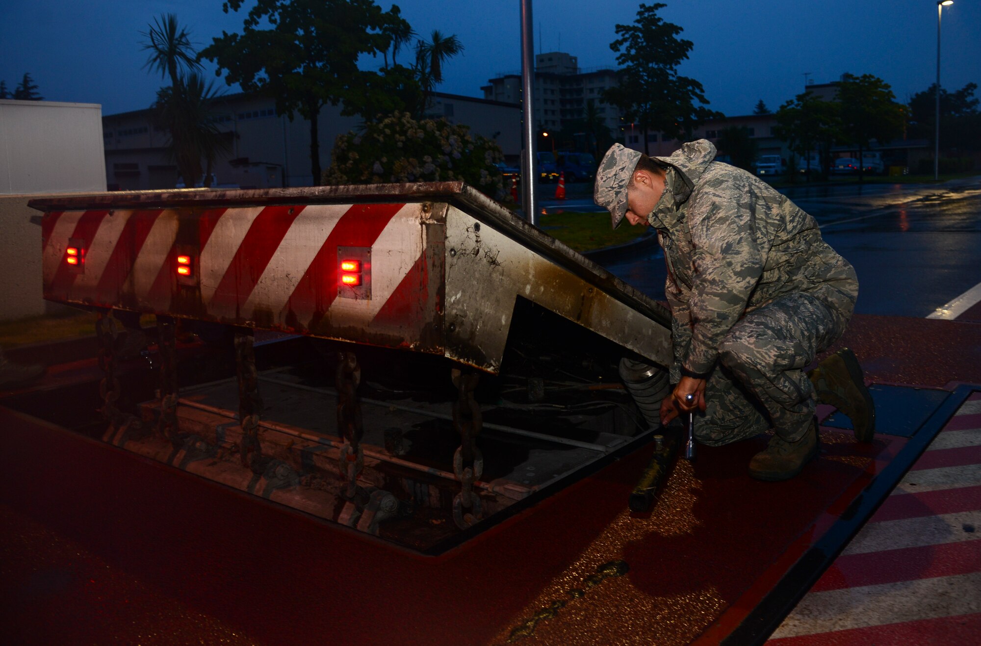Senior Airman Michael Wood, 374th Civil Engineer Squadron electrical power production journeyman, loosens a bolt on an anti-vehicle barrier at Yokota Air Base, Japan, July 23, 2015. Power production Airmen perform inspections on the anti-vehicle barrier system weekly, monthly and quarterly. (U.S. Air Force photo by Senior Airman David Owsianka/Released)