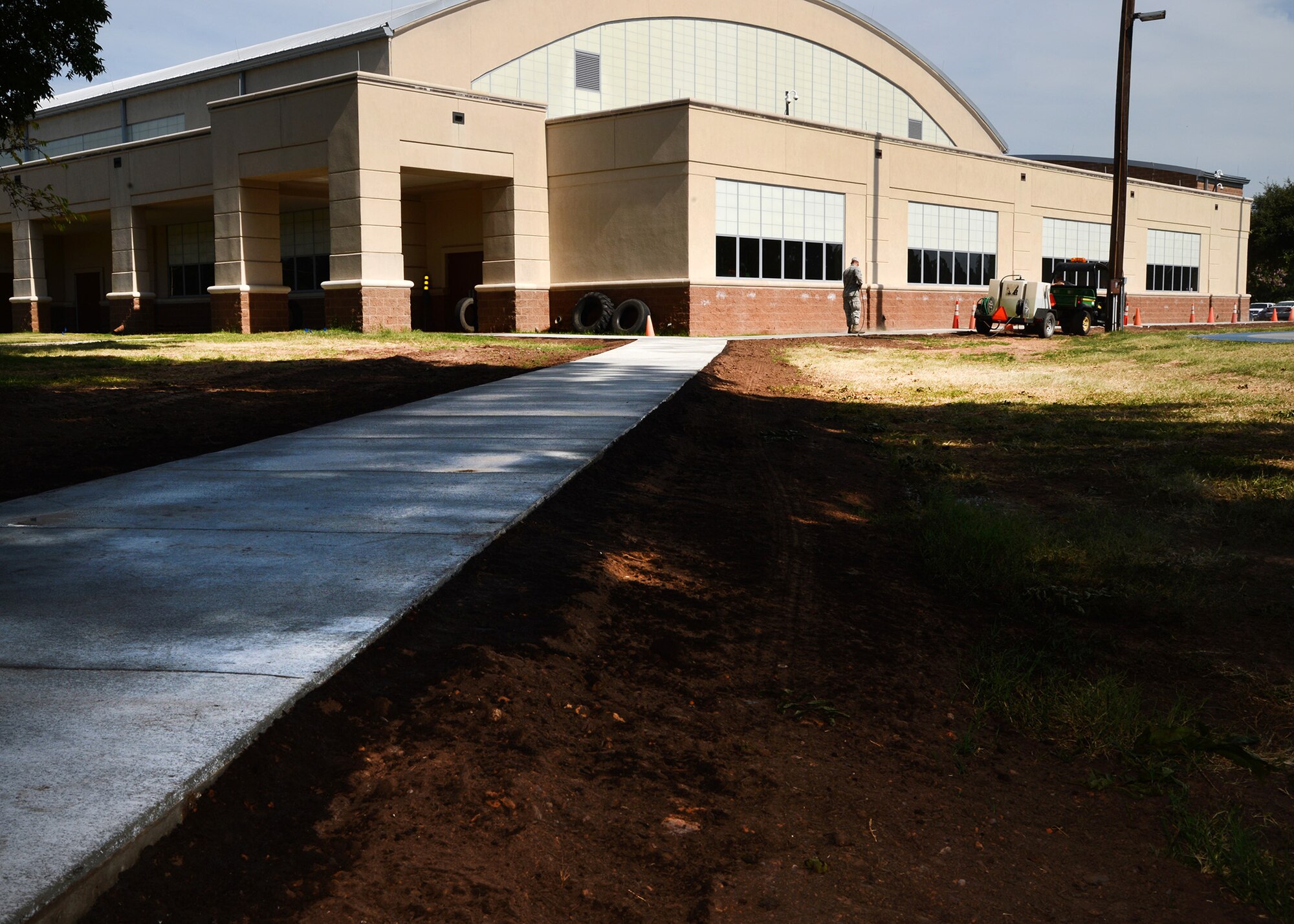 Airmen from the 2nd Civil Engineer Squadron pavements and equipment flight clean off a newly installed sidewalk at the Senior Airman Bryan Bell Fitness Center on Barksdale Air Force Base, La., July 21, 2015. The sidewalk was installed to create an easier and safer path to the gym for Airmen living in the dorms. (U.S. Air Force photo/Senior Airman Joseph A. Pagán Jr.) 