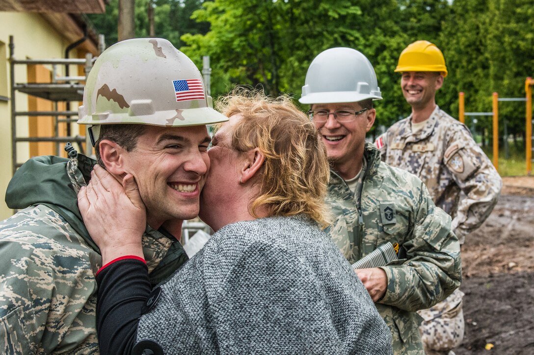 U.S. Air Force Capt. Joseph Morrey (left) with the 139th Civil Engineering Squadron, Missouri Air National Guard, is kissed on the cheek for thanks by Lilita Gasjaneca, director of the Naujenu Orphanage, during the reconstruction of the Naujenu Orphanage near Daugavpils, Latvia, July 20, 2015.  The 139th CE was participating in the Humanitarian Civic Assistance project that pairs units trainings requirements with humanitarian needs.  (U.S. Air National Guard photo by Senior Airman Patrick P. Evenson/Released)