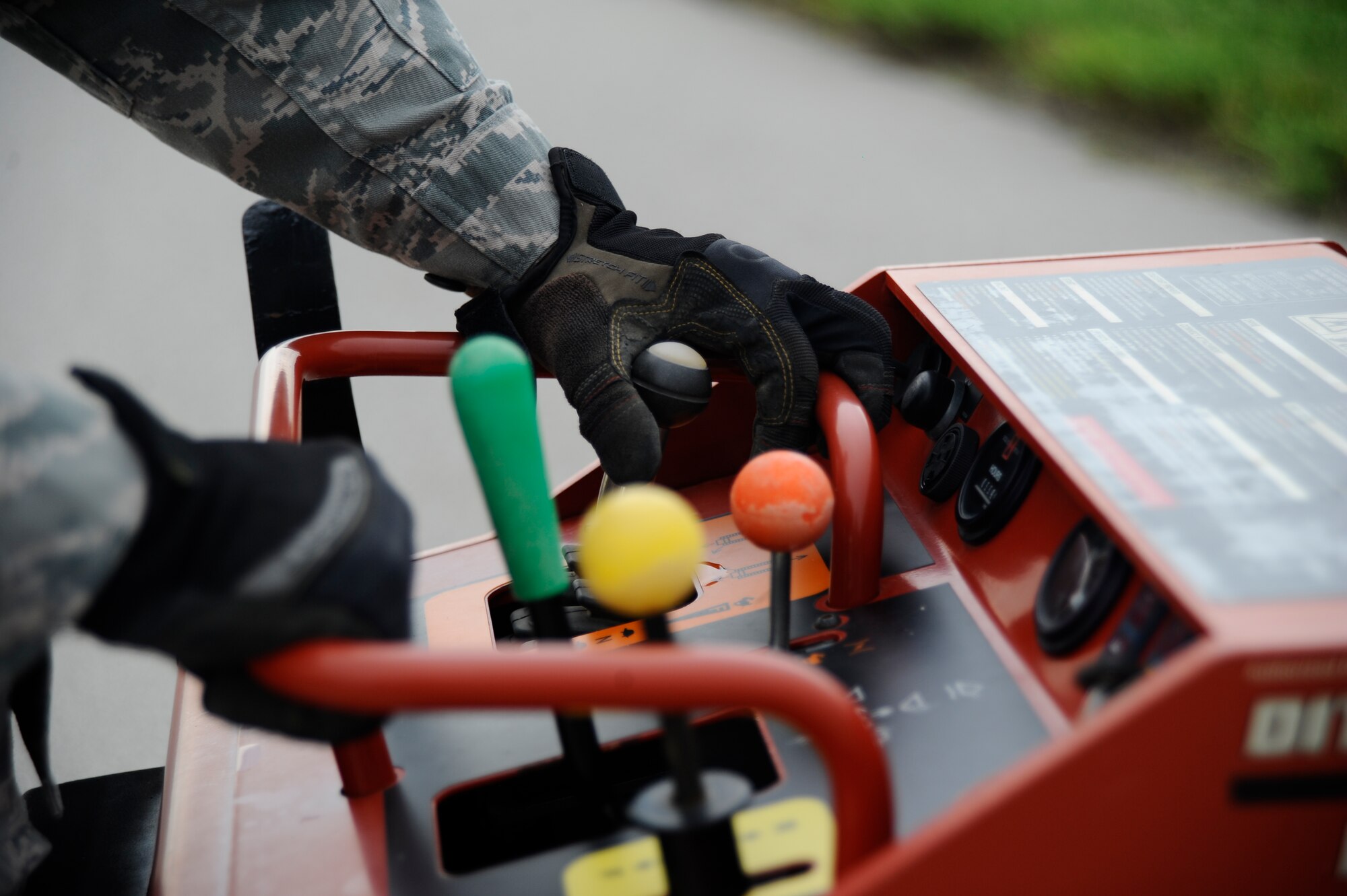 Senior Airman Michael Macaraig, 22nd Civil Engineer Squadron horizontal pavements shop heavy equipment operator, operates a mini skid steer unit, July 22, 2015, at McConnell Air Force Base, Kan. Macaraig used the heavy machinery to easily transport multiple top rails for a perimeter fence that he and  his fellow “Dirt Boyz” were constructing. (U.S. Air Force photo by Senior Airman Victor J. Caputo)