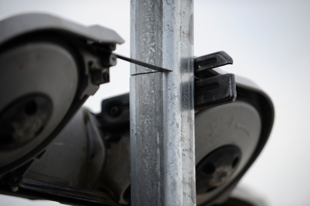 A “Dirt Boy” from the 22nd Civil Engineer Squadron horizontal pavements shop cuts a fence post, July 22, 2015, at McConnell Air Force Base, Kan. The “Dirt Boyz” earned their nickname through the use of heavy equipment in different projects that often involve digging up dirt to lay a foundation or anchor an object into the ground. (U.S. Air Force photo by Senior Airman Victor J. Caputo)