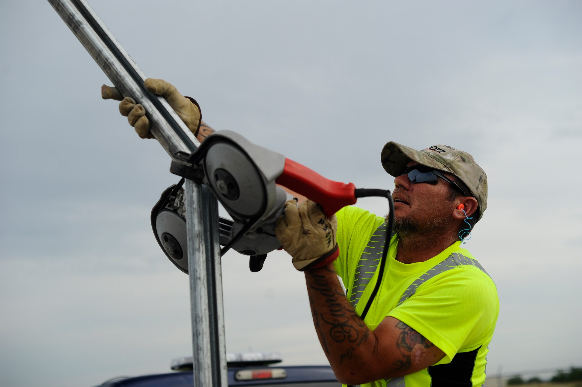Bobby Wren, 22nd Civil Engineer Squadron horizontal pavements shop heavy equipment operator, saws a fence post down to the correct height, July 22, 2015, at McConnell Air Force Base, Kan. Each post must be seven feet tall from the ground, requiring precision cuts for a straight fence line. (U.S. Air Force photo by Senior Airman Victor J. Caputo)