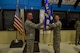 Col. Joel Degroot, 114th Maintenance Group commander, passes the 114th Maintenance Squadron (MXS) guidon to Lt. Col. Travis Boltjes, the incoming 114th MXS commander, during a change of command ceremony at Joe Foss Field, S.D., July 12, 2015. The primary purpose of a change of command ceremony is to allow subordinates to witness the formality of command change from one officer to another. The 114th MXS is the largest squadron on base with almost 250 Airmen. (National Guard photo by Staff. Sgt. Luke Olson/Released)