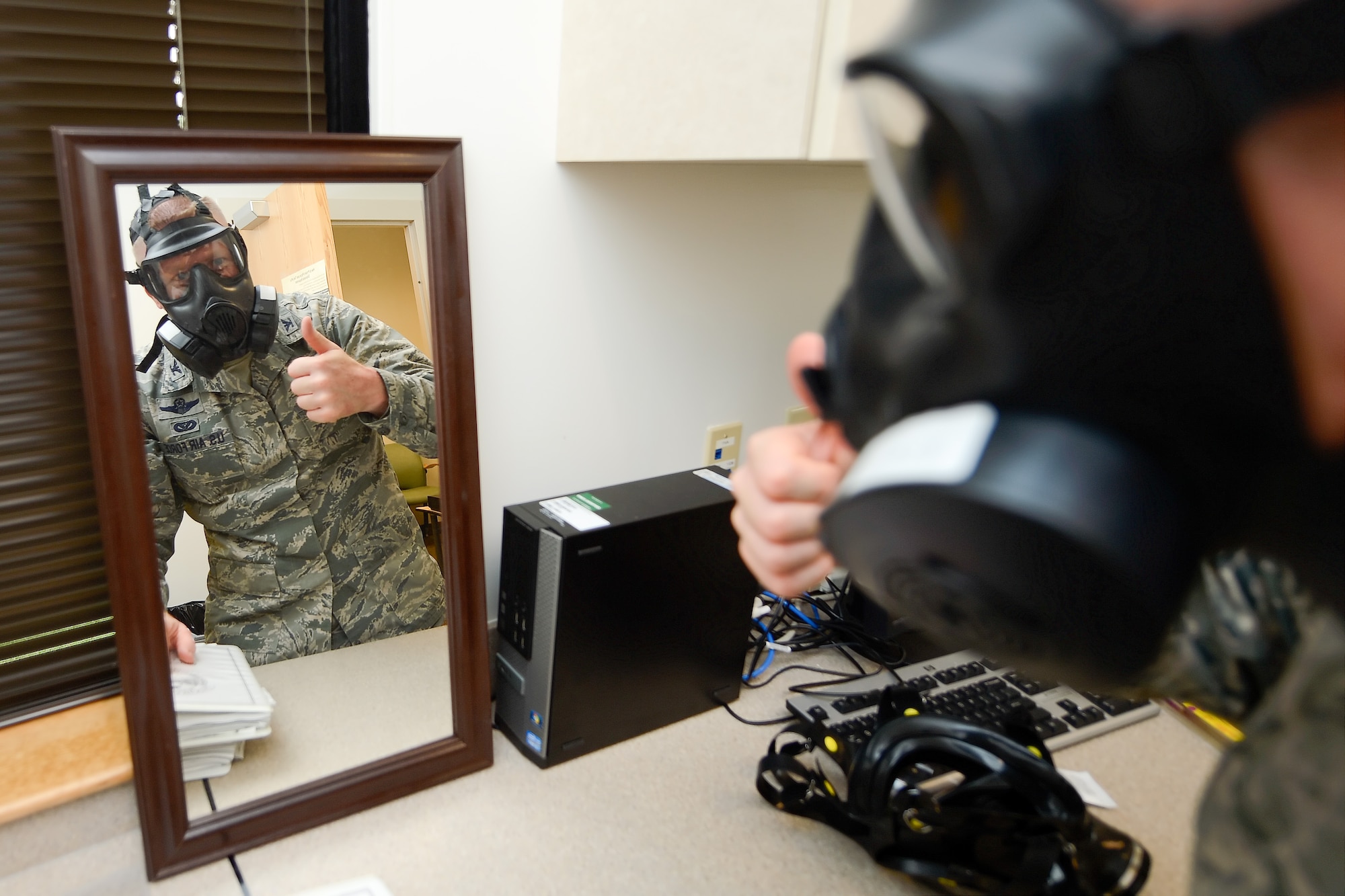 Col. Michael Grismer, 436th Airlift Wing commander, gives a thumbs-up indicating he has a tight, leak-free fit on a M50 joint service protective gas mask that he has donned during a visit to the 436th Aerospace Medicine Squadron Biological Environmental Flight July 17, 2015, at Dover Air Force Base, Del. Grismer donned the gas mask and did a fit and function test while learning about the mission of the flight during his visit. (U.S. Air Force photo/Greg L. Davis)