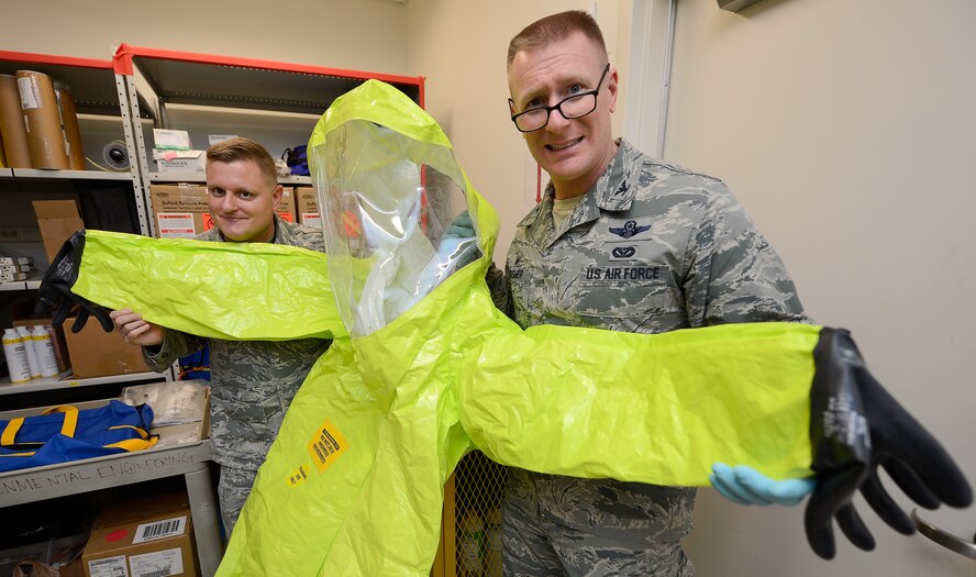 Col. Michael Grismer, 436th Airlift Wing commander, right, and Chief Master Sgt. John Elstrom, 436th Maintenance Group superintendent, pose with a Level A hazardous material suit during a visit to the 436th Aerospace Medicine Squadron Biological Environmental Flight July 17, 2015, at Dover Air Force Base, Del. Grismer and Elstrom learned about the mission capabilities of the specialized flight during their visit. (U.S. Air Force photo/Greg L. Davis)