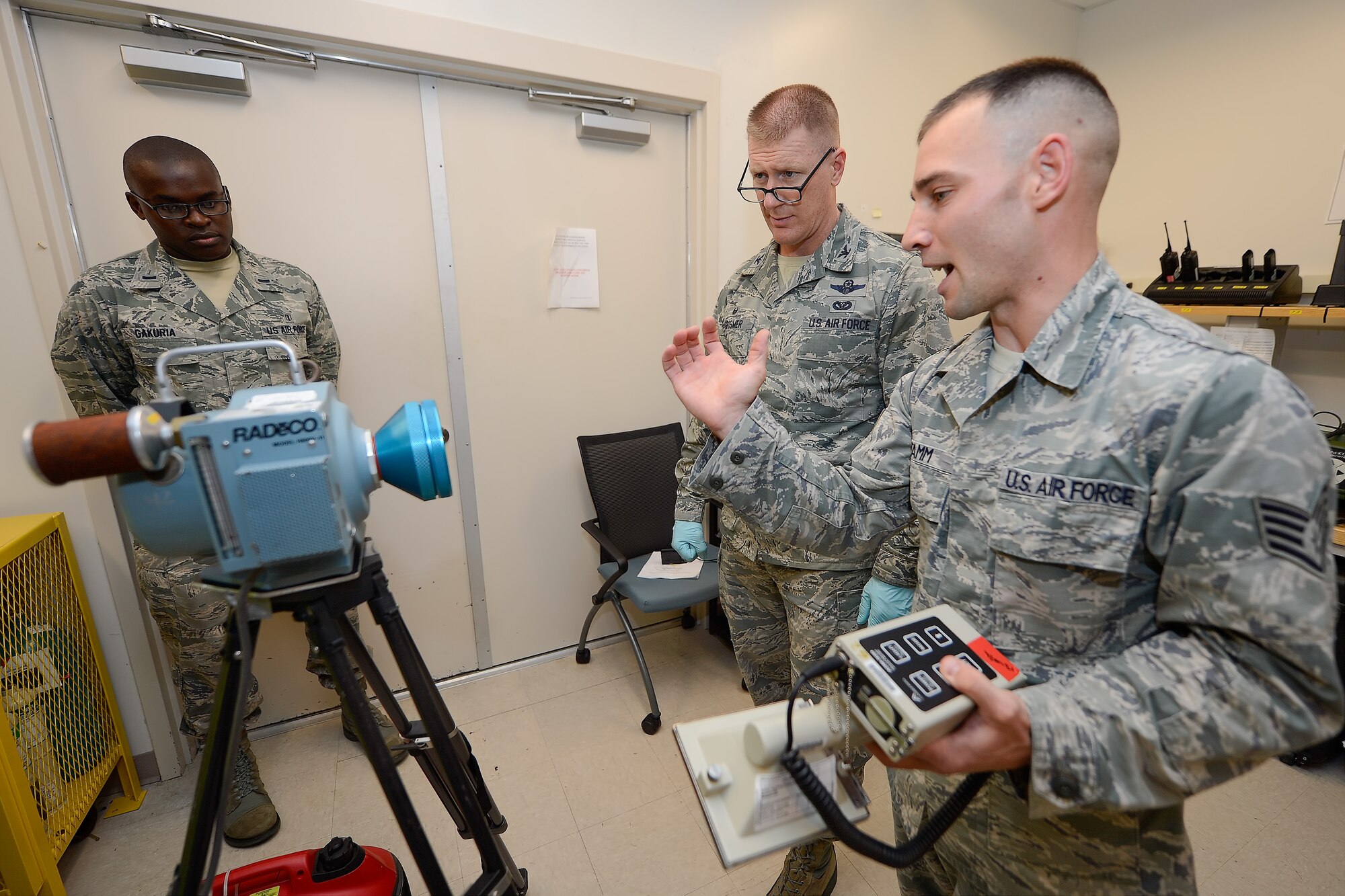 Col. Michael Grismer, 436th Airlift Wing commander, center, listens as Staff Sgt. Jeffry Stamm, 436th Aerospace Medicine Squadron, Readiness Flight NCO in charge, right, describes the functions of a high-volume air sampler used for detecting radioactive particles suspended in the air July 17, 2015, at Dover Air Force Base, Del. Grismer visited to learn about the unit???s mission and capabilities. (U.S. Air Force photo/Greg L. Davis)