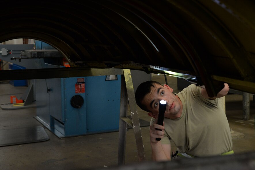 Senior Airman Dylan Fox, 707th Maintenance Squadron aircraft structural maintenance journeyman, conducts a final inspection of the upper body cowling on Barksdale Air Force Base, La., July 20, 2015. The fabrication flight is responsible for maintaining aircraft and checking for corrosion, building parts and X-raying aircraft. Repairing B-52 Stratofortress locally saves repair times and cost. (U.S. Air Force photo/Senior Airman Jannelle Dickey)